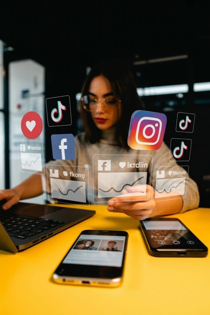 5a6a96d046c84ebfd42fd9e3f08ceb21 A woman in glasses working on a laptop, interacting with holographic icons of social media platforms, including Instagram, Facebook, and TikTok